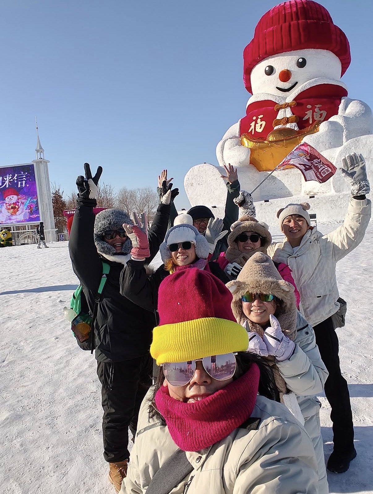 团员与哈尔滨大雪人在冬日晴空下合影