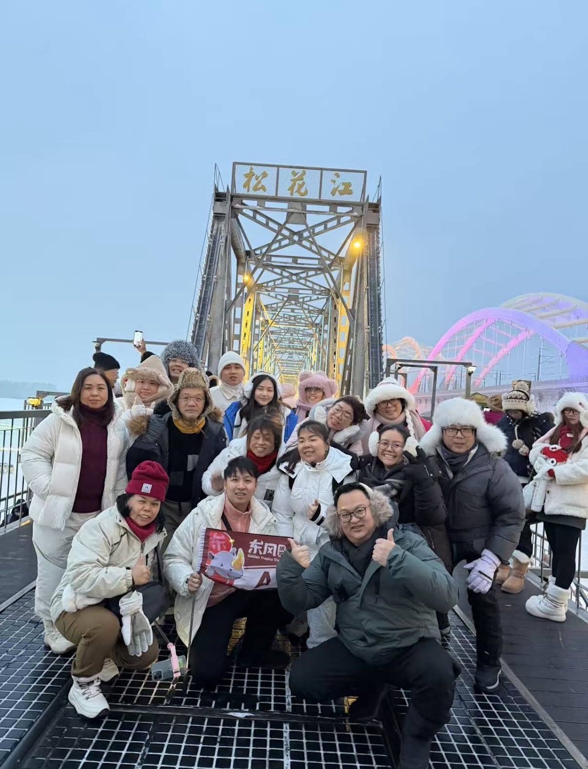 东风旅游团员在冰封松花江上的老铁路桥合影
